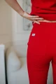 Stylowe spodnie medyczne Basic Poppy, dopasowane do bluzy w intensywnym kolorze maku, doskonałe dla profesjonalistów pracujących w salonach kosmetycznych i fizjoterapeutycznych.