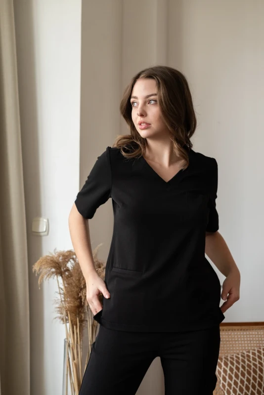 Stylowa bluzka medyczna Classy Blackberry, o intensywnej czerni, idealna dla kobiet pracujących w różnych dziedzinach medycyny, oferująca nie tylko wygodę, ale także niepowtarzalny styl i elegancję.