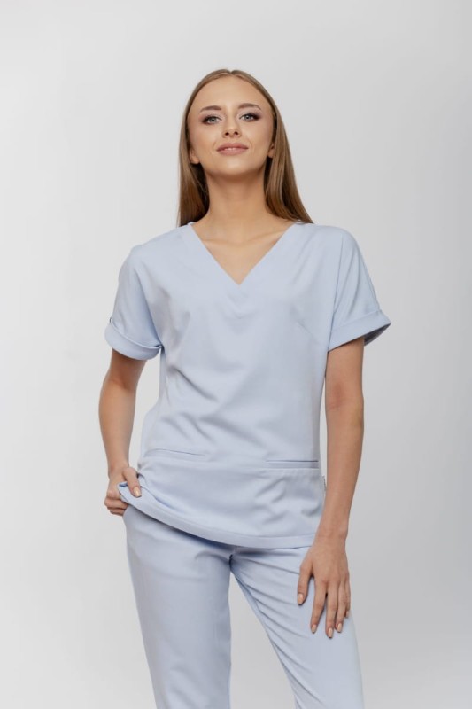 Uniform medyczny w pastelowym błękicie prezentowany na modelce – połączenie elegancji, komfortu i jakości wykonania od Medibreath.